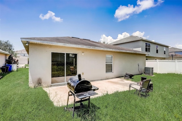 back of house with a lawn, a patio area, and central AC