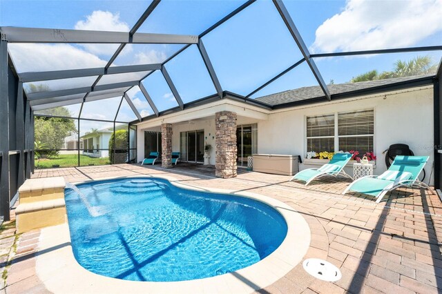 view of swimming pool with pool water feature, glass enclosure, and a patio