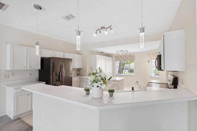 kitchen featuring white cabinetry, rail lighting, hanging light fixtures, and appliances with stainless steel finishes