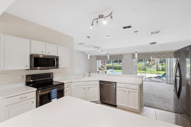 kitchen featuring light carpet, white cabinets, hanging light fixtures, sink, and appliances with stainless steel finishes