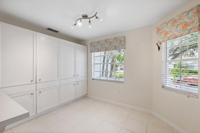 tiled spare room with a healthy amount of sunlight