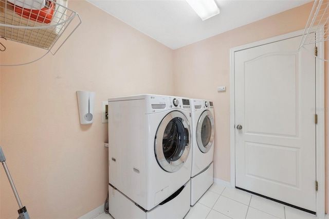 laundry area featuring light tile patterned floors and washer and clothes dryer