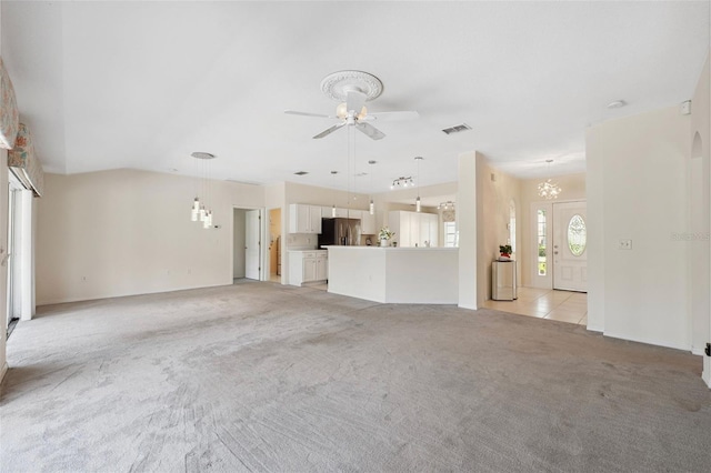 unfurnished living room with light colored carpet, vaulted ceiling, and ceiling fan