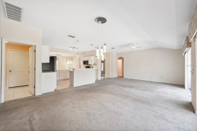 unfurnished living room featuring ceiling fan, light colored carpet, and lofted ceiling