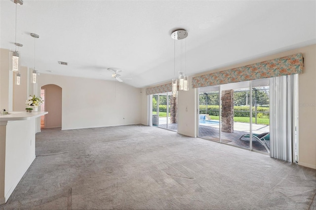 unfurnished living room featuring ceiling fan, light colored carpet, and vaulted ceiling