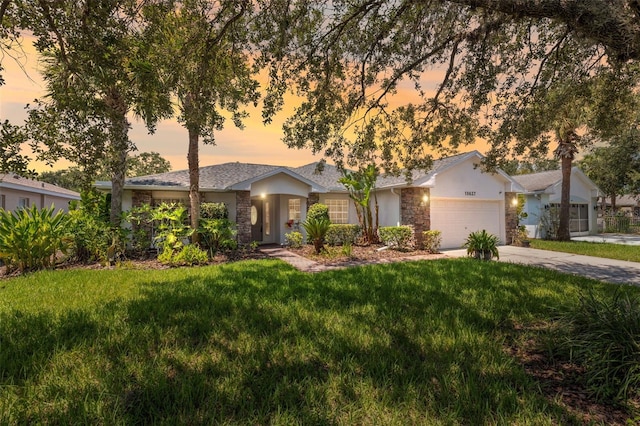 single story home with a garage and a lawn