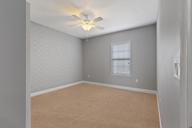 carpeted empty room with a textured ceiling and ceiling fan