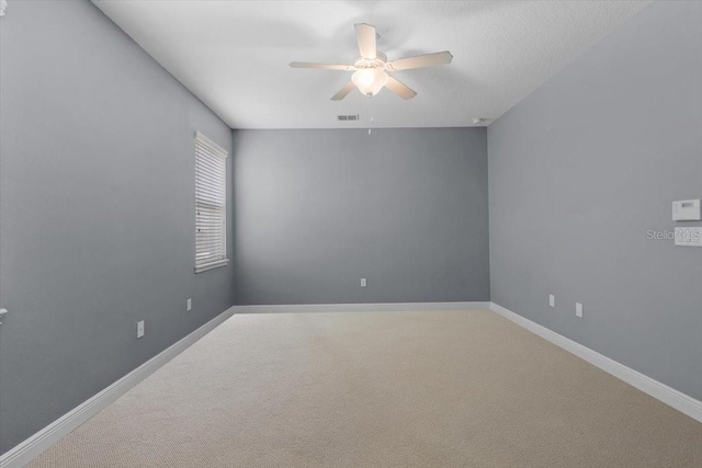 empty room featuring carpet floors and ceiling fan