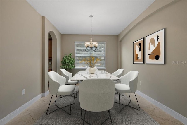 dining space with light tile patterned flooring and a chandelier