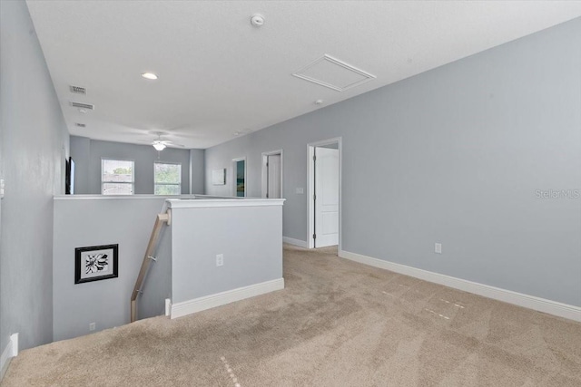 empty room with ceiling fan and light colored carpet