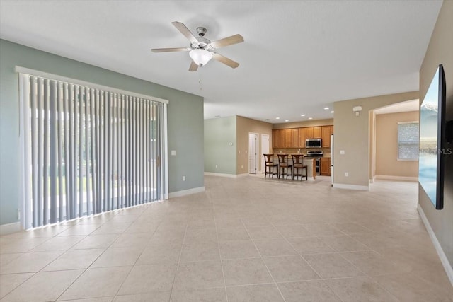 unfurnished living room featuring ceiling fan and light tile patterned floors