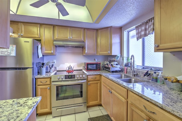 kitchen featuring ceiling fan, sink, light tile patterned flooring, appliances with stainless steel finishes, and light stone counters