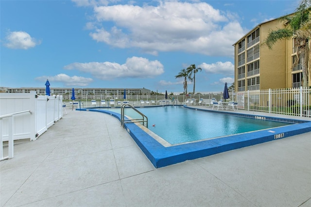 view of pool featuring a patio area and a water view