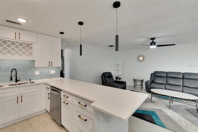 kitchen with decorative light fixtures, backsplash, ceiling fan, white cabinets, and sink