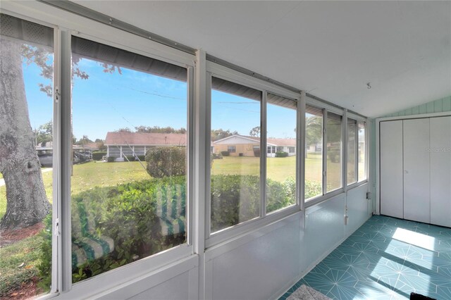 unfurnished sunroom featuring vaulted ceiling