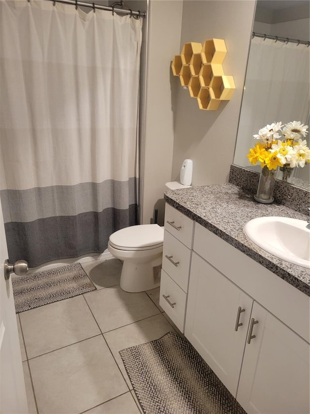 bathroom featuring toilet, tile flooring, and vanity