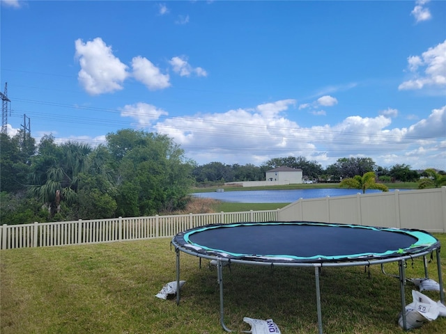 view of swimming pool featuring a yard and a trampoline