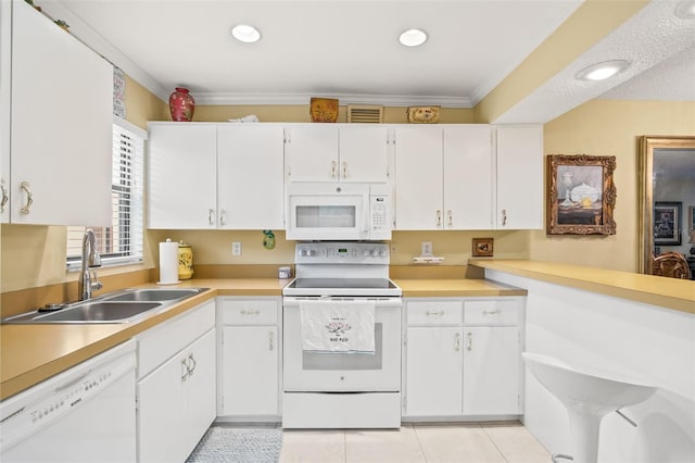 kitchen featuring white cabinets, sink, white appliances, light tile flooring, and ornamental molding