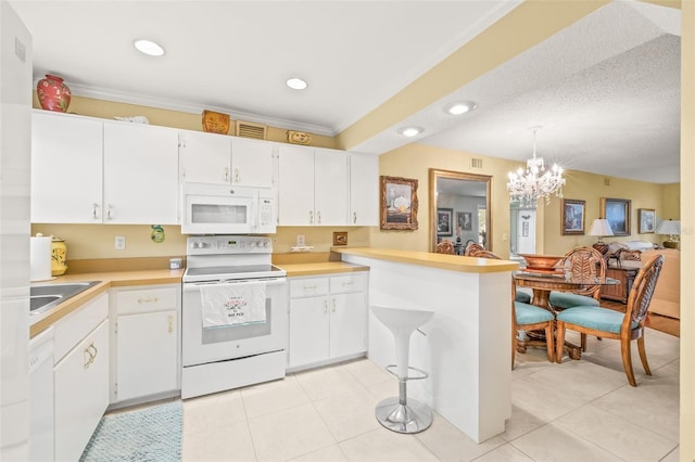 kitchen with decorative light fixtures, white appliances, white cabinetry, and light tile floors