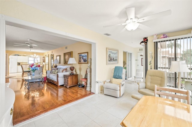 living room with ceiling fan, light tile floors, and a wealth of natural light