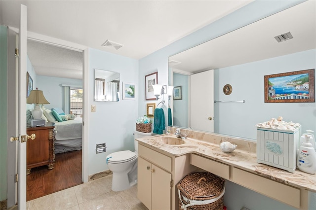 bathroom with tile floors, toilet, and oversized vanity