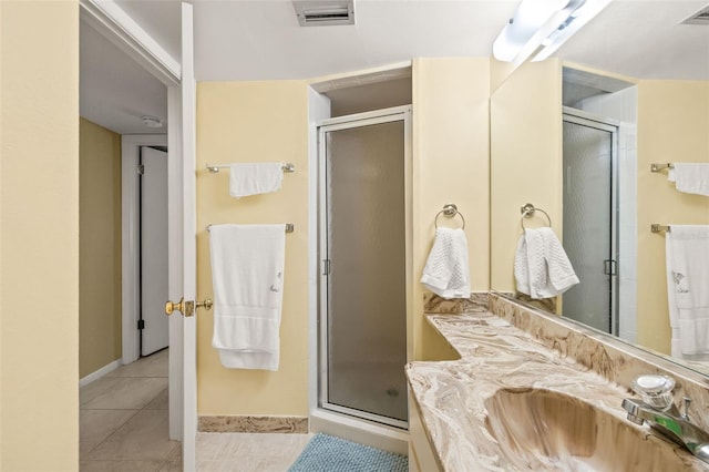 bathroom with a shower with shower door, tile floors, and large vanity