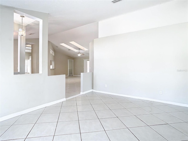 tiled spare room featuring vaulted ceiling and ceiling fan