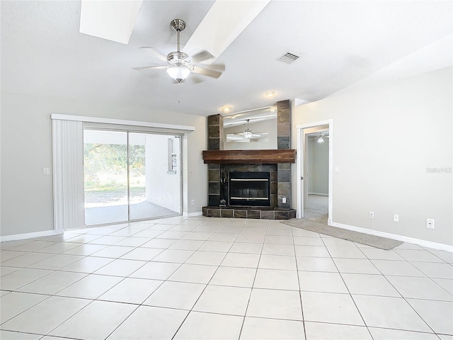 unfurnished living room with a tiled fireplace, light tile patterned floors, and ceiling fan