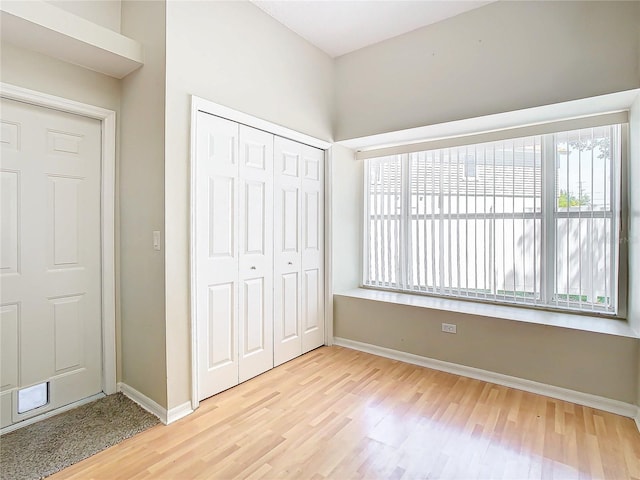 unfurnished bedroom with a closet and light hardwood / wood-style flooring