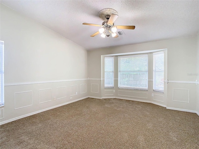 carpeted spare room featuring ceiling fan and a textured ceiling