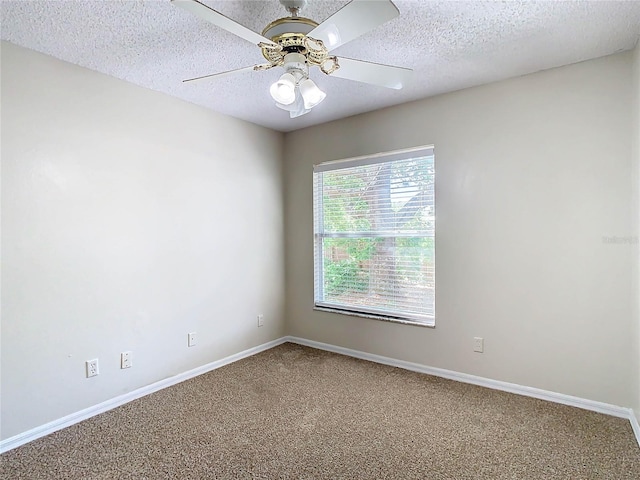empty room featuring ceiling fan, carpet, and a textured ceiling