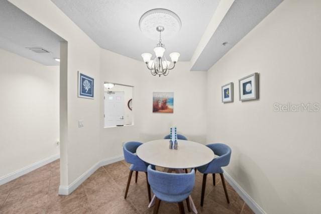 tiled dining space with an inviting chandelier