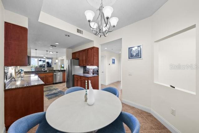 tiled dining area featuring an inviting chandelier