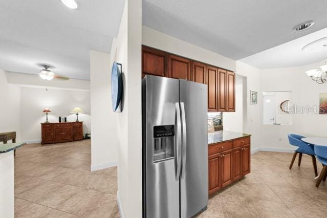 kitchen featuring ceiling fan with notable chandelier, light tile flooring, and stainless steel fridge with ice dispenser