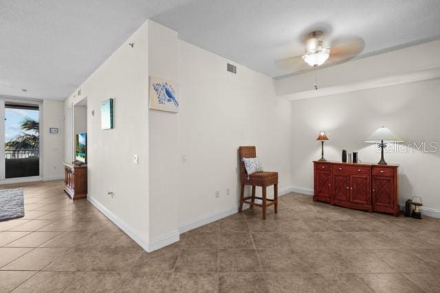 living area featuring ceiling fan and light tile floors