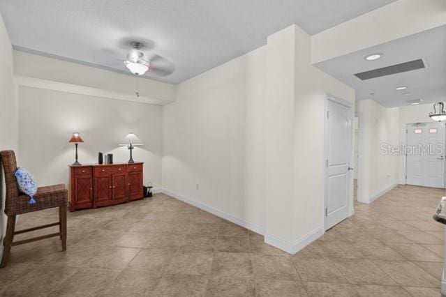 sitting room featuring ceiling fan and light tile floors