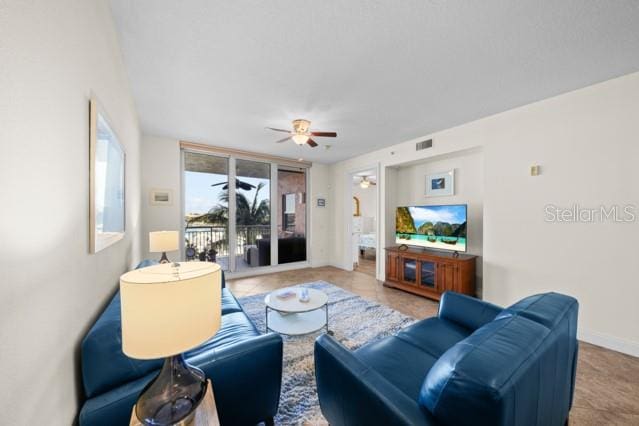 living room featuring ceiling fan and light tile floors