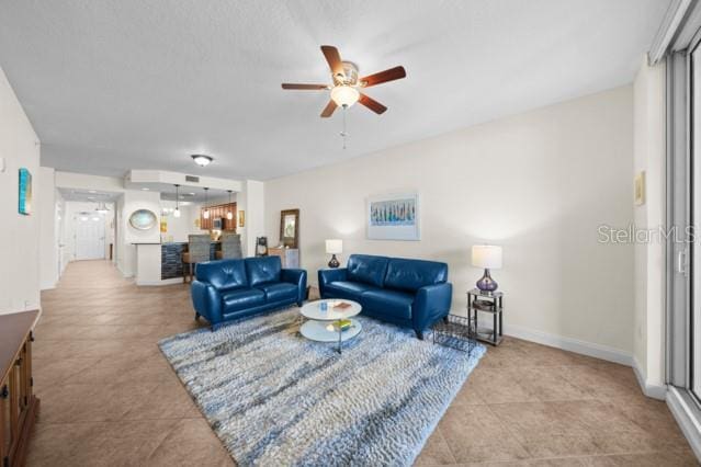 living room with ceiling fan and light tile floors