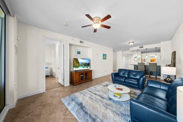 tiled living room featuring ceiling fan