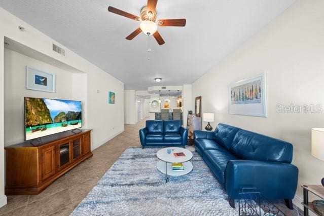 tiled living room with ceiling fan