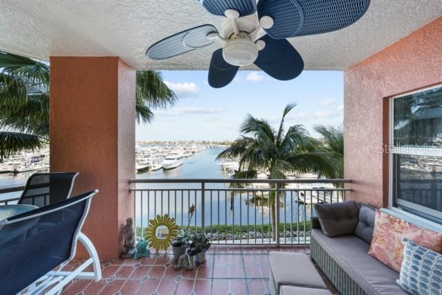 balcony featuring ceiling fan and a water view