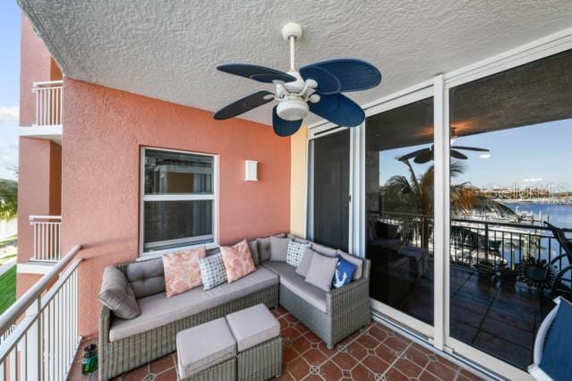 balcony featuring ceiling fan, a water view, and outdoor lounge area