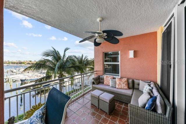 balcony featuring outdoor lounge area, a water view, and ceiling fan