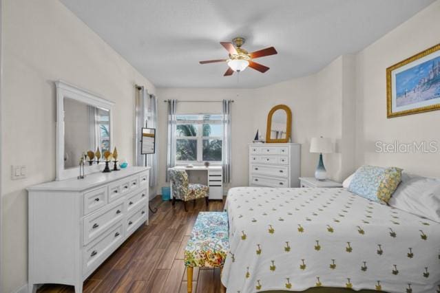 bedroom with dark hardwood / wood-style flooring and ceiling fan