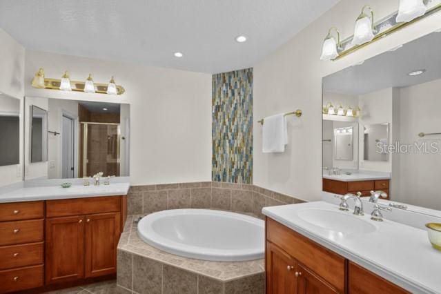 bathroom with double sink, tile flooring, separate shower and tub, and vanity with extensive cabinet space