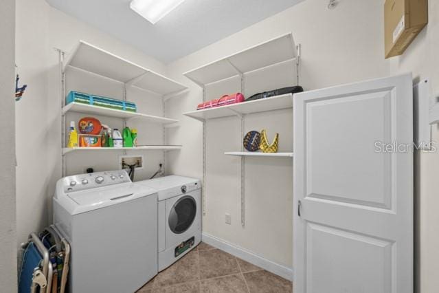 laundry area with light tile floors, washer and dryer, and hookup for a washing machine