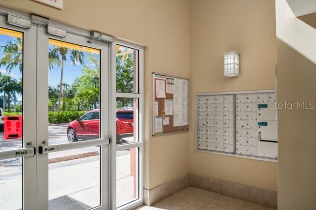 doorway with french doors, light tile floors, and plenty of natural light