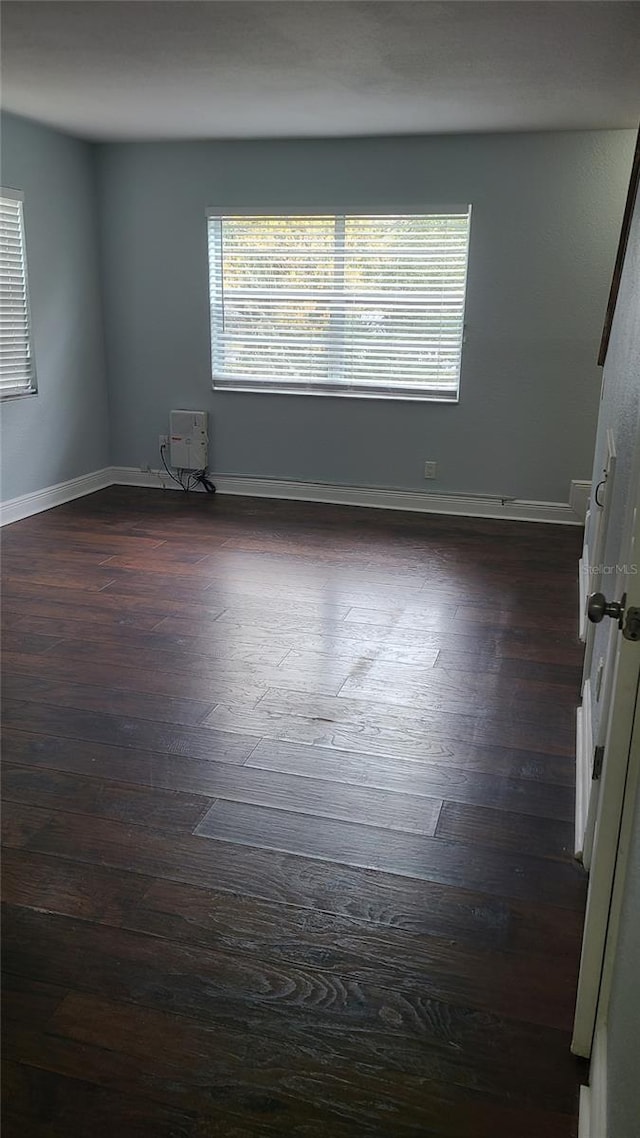 spare room with dark hardwood / wood-style flooring