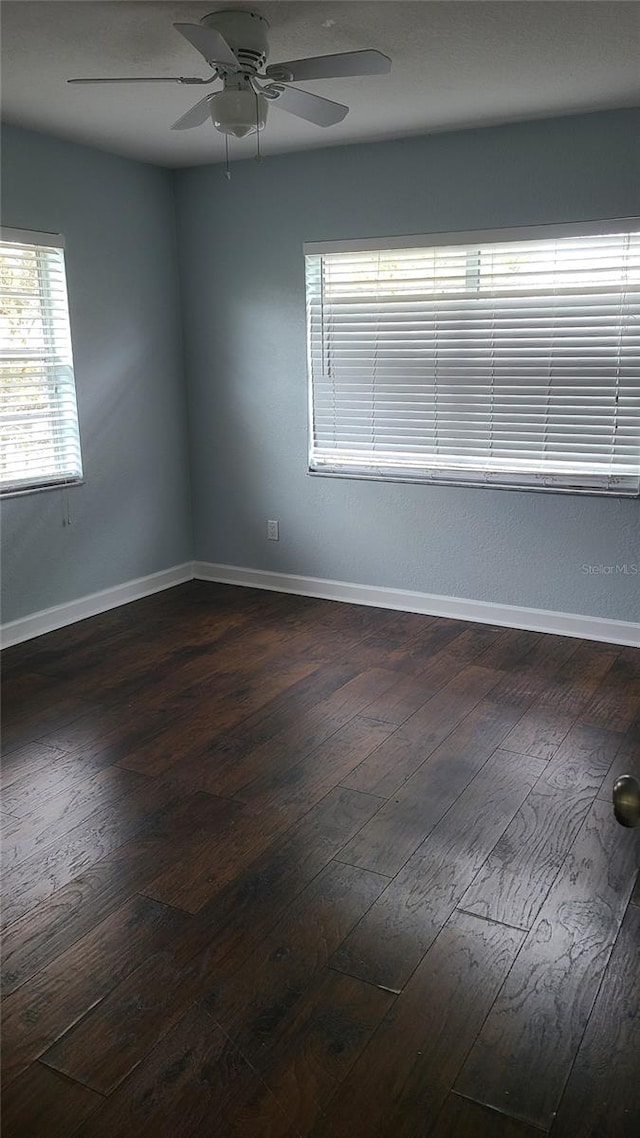 spare room with ceiling fan and dark hardwood / wood-style flooring