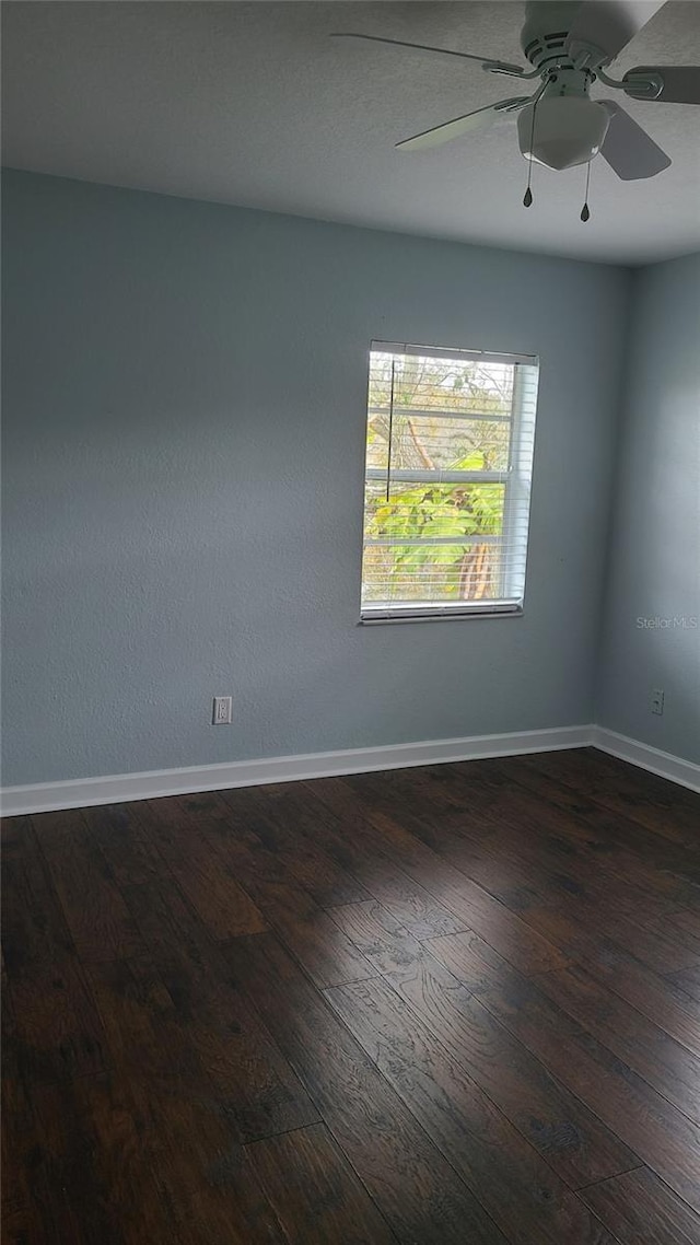 empty room with ceiling fan and dark hardwood / wood-style floors